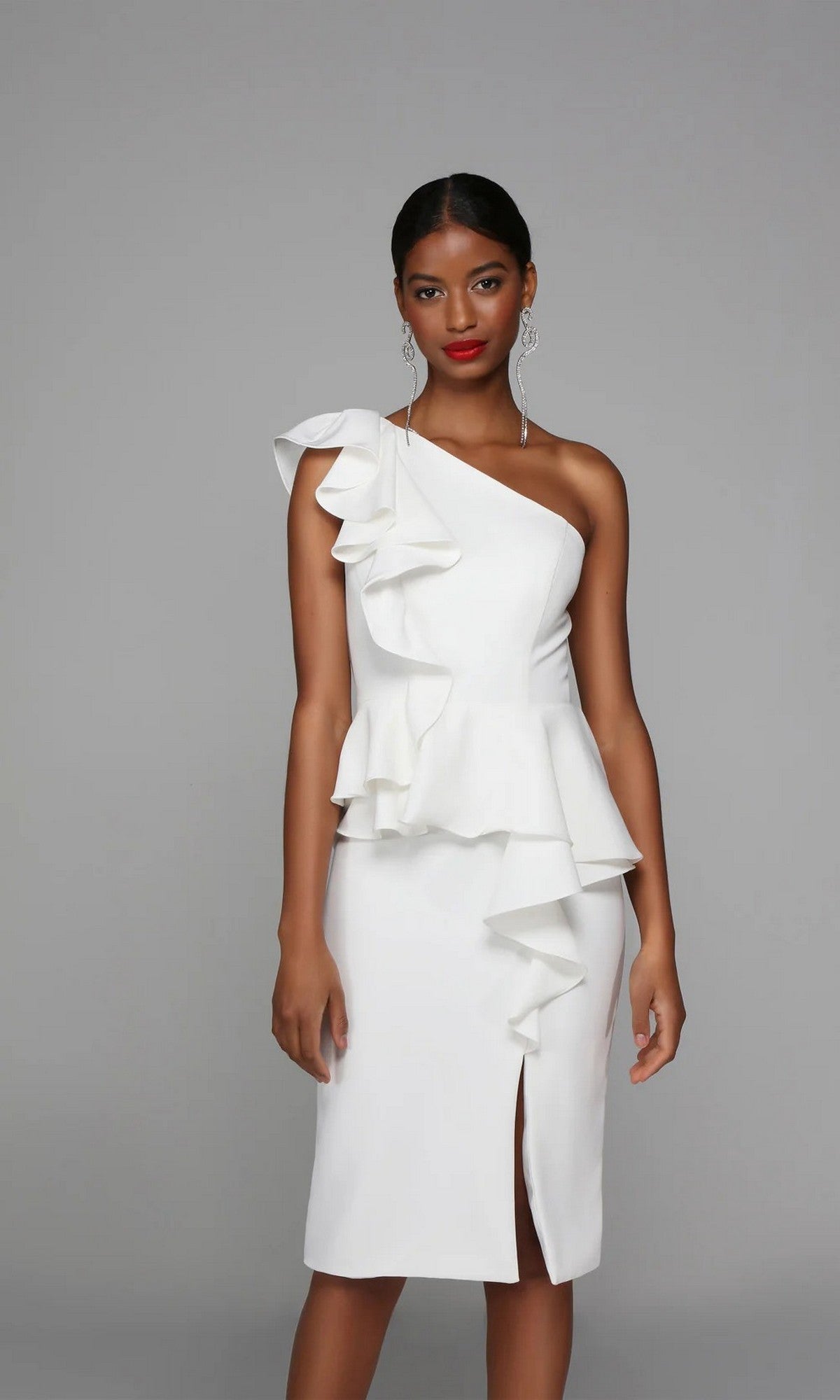 A woman models the Alyce 70007 Knee Length White Party Dress, a one-shoulder ruffle sheath with a front slit, against a plain gray background.